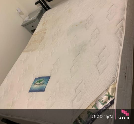 מזרן עם כתמים על מיטה בחדר שינה